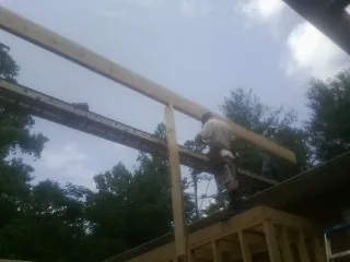 Carpenter setting a ridge beam over a new addition frame — Ice Dam Removal by Roofing Brothers in Rogue River